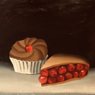a small cake with a cherry on top and a cherry filled pie