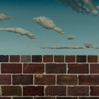 A brick wall with a blue sky and clouds